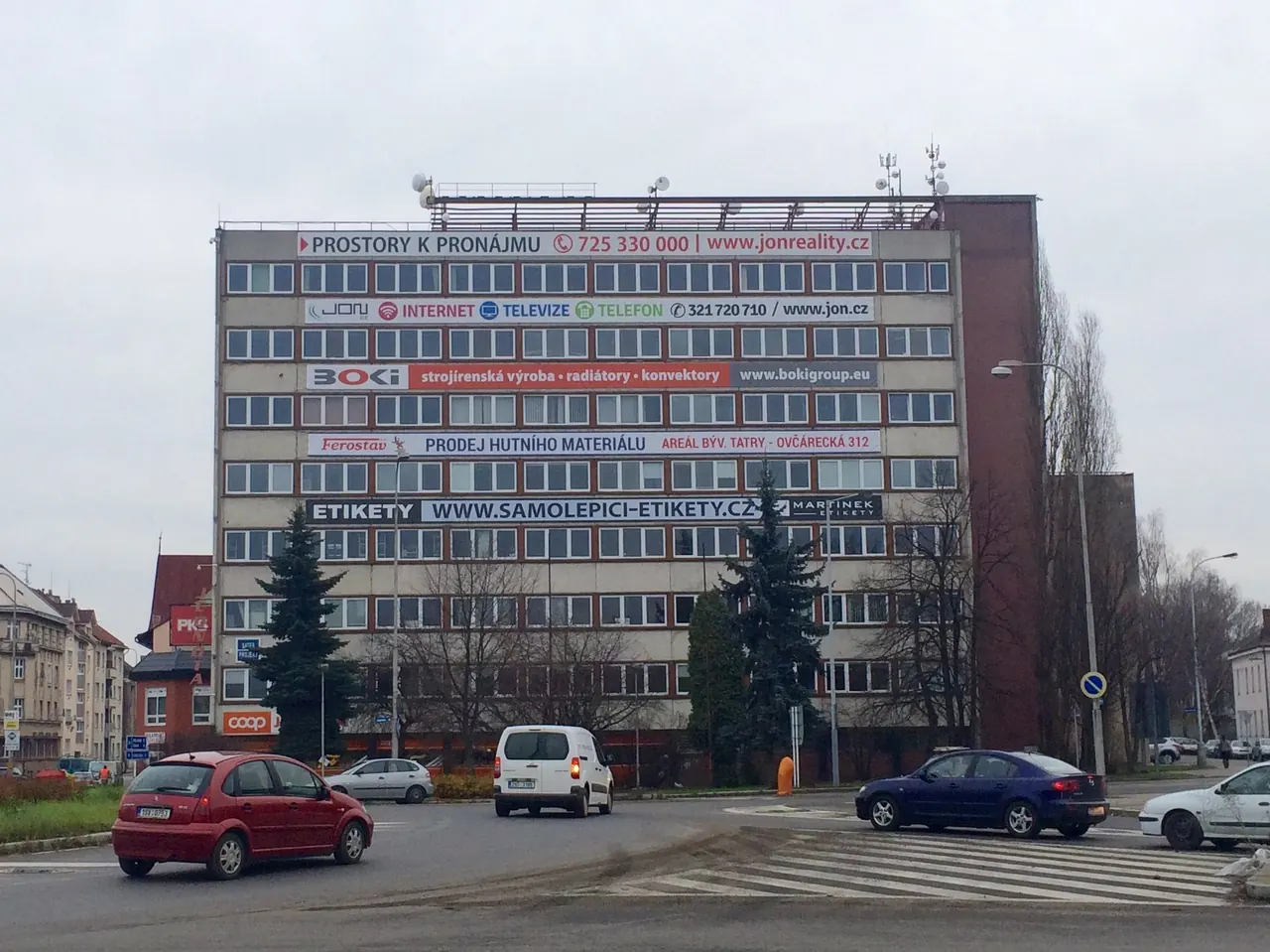 Fasáda budovy Plynárenská 671 s reklamními plachtami u kruhového objezdu